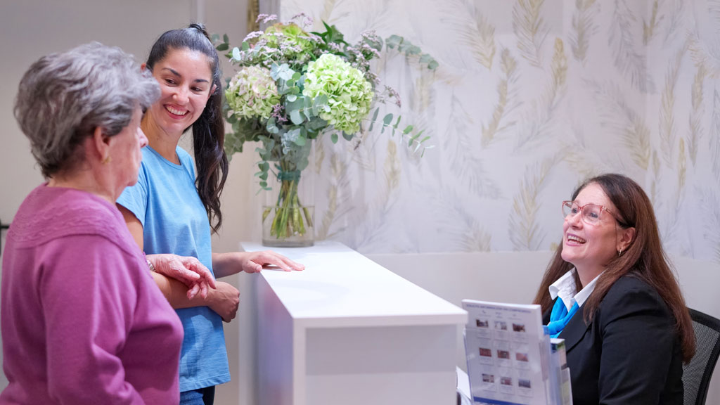 Couloir lumineux d'EHPAD avec panneau d'affichage équipe visible de loin