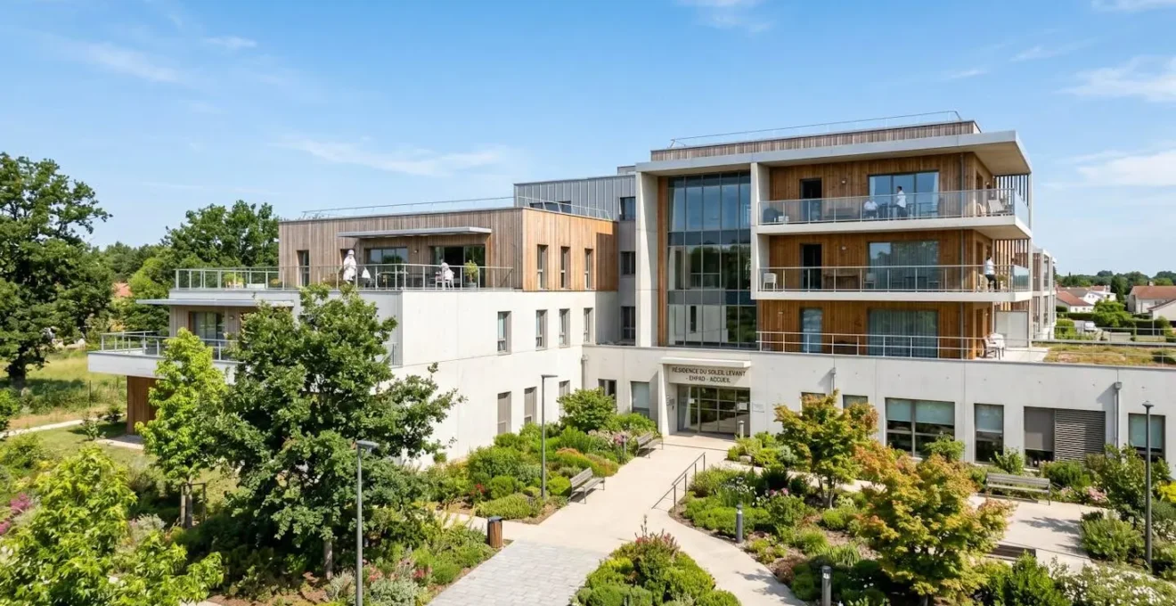 Vue en grand angle d'un bâtiment EHPAD contemporain avec façade moderne et jardin paysagé sous un ciel bleu